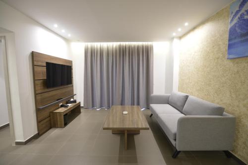 a living room with a couch and a tv at Zett hotel in Jounieh
