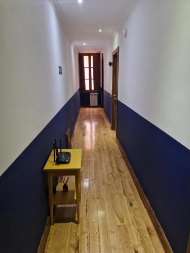 a hallway with a table and a blue and white wall at Pepe's Place - Carlo Alberto in Rome