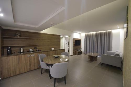 ein Wohnzimmer mit Tisch und Stühlen und eine Küche in der Unterkunft Zett hotel in Jounieh