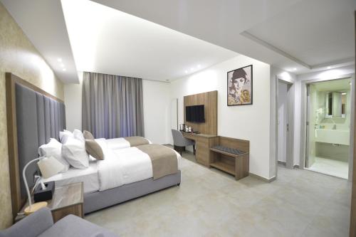 a bedroom with a bed and a desk and a television at Zett hotel in Jounieh