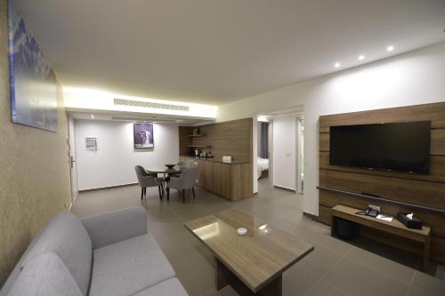 a living room with a couch and a flat screen tv at Zett hotel in Jounieh