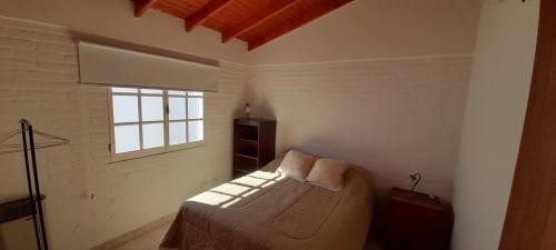 un dormitorio con una cama y una ventana en Los Choiques Madryn, en Puerto Madryn