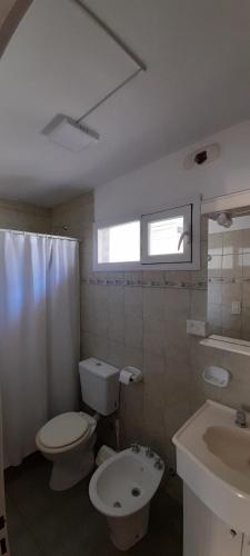 a bathroom with a toilet and a sink at Los Choiques Madryn in Puerto Madryn