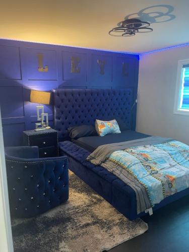 a blue bedroom with a bed with a blue headboard at Luxury Modern smart home for vacation in Windsor