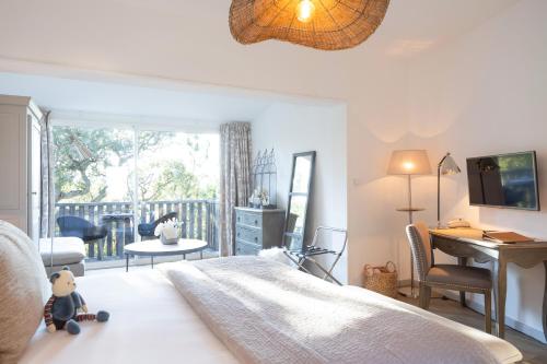a bedroom with a large bed with a desk and a desk at Hôtel Font Mourier in Cogolin