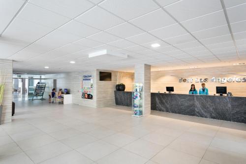 an office lobby with a reception desk and people at Hotel Best Los Angeles in Salou