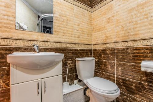 a bathroom with a toilet and a sink and a mirror at Star Rent Hotel in Chişinău