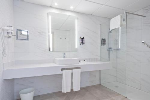 a white bathroom with a sink and a mirror at Hotel Best Punta Dorada in Salou