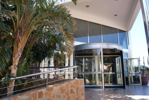 eine Lobby eines Gebäudes mit Glastüren und Palmen in der Unterkunft Hotel Best Oasis Tropical in Mojácar