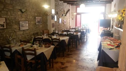 a restaurant with tables and chairs in a room at Hotel Capriolo in Vidiciatico