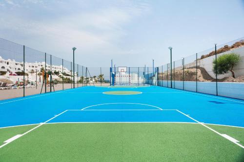 a blue tennis court with a playground on it at Best Club Vacaciones Pueblo Indalo in Mojácar