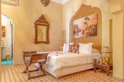 a bedroom with a large bed and a mirror at Demeures d'Orient Riad & Spa in Marrakesh