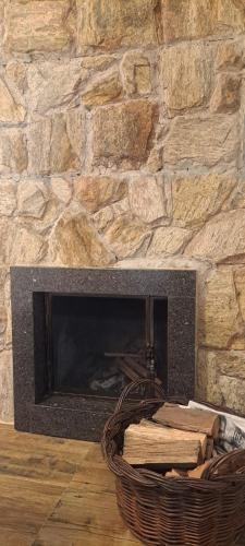 a stone fireplace with a basket in front of it at Locanda Montecielo Pousada Boutique - Vale dos Vinhedos in Bento Gonçalves