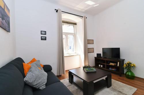 a living room with a blue couch and a coffee table at Apartment Stross Rijeka in Rijeka