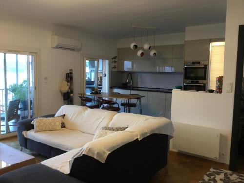 a living room with a white couch and a kitchen at Ajaccio . chambre avec vue in Ajaccio