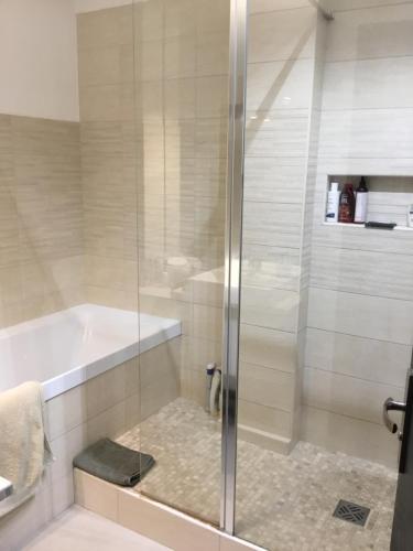 ducha con puerta de cristal junto a la bañera en Ajaccio . chambre avec vue en Ajaccio