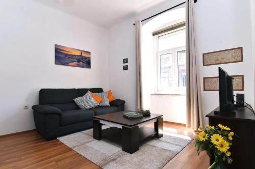 a living room with a couch and a coffee table at Apartment Stross Rijeka in Rijeka