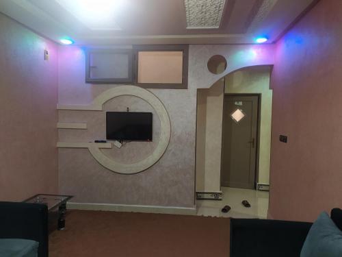 una camera con una parete, una TV e uno specchio di شقق فندقية بن خليل /hôtel appartements Bin khlil a Tan-Tan