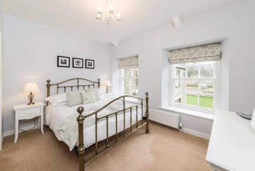a bedroom with a bed and a window at Coach House, Middleton Hall Estate in Belford