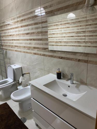 a bathroom with a white sink and a toilet at Quinta da Travessa in Cinfães