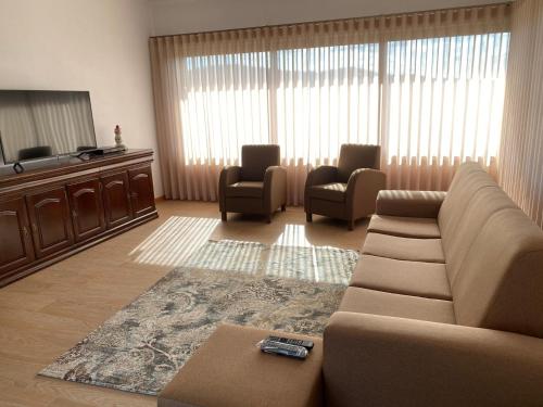 een woonkamer met een bank en twee stoelen bij Quinta da Travessa in Cinfães