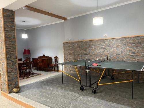 una mesa de ping pong en una habitación con una pared de ladrillo en Quinta da Travessa, en Cinfães