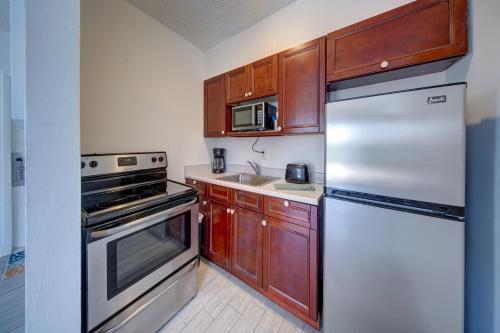 a kitchen with stainless steel appliances and wooden cabinets at Blue Strawberry by the Sea in Fort Lauderdale