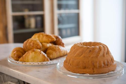 een tafel met 2 borden met zoete deegwaren en croissants bij Casa Castagna 1620 in Mergozzo