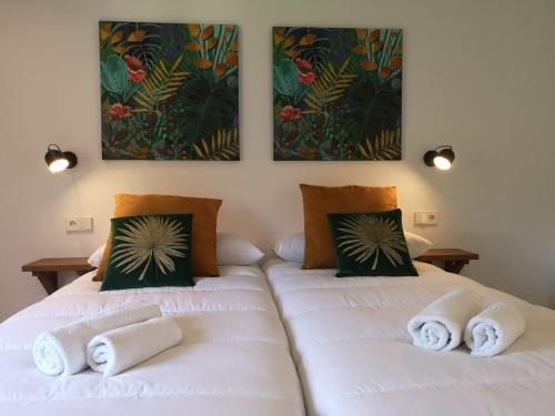 two beds in a room with white sheets at Villa Arbona Dalt in Sóller