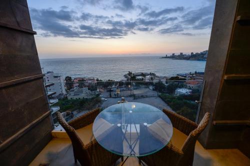 a table with chairs and a view of the ocean at Zett hotel in Jounieh