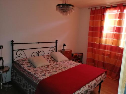 a bedroom with a bed with a red blanket at Appartamento Angela in Cento