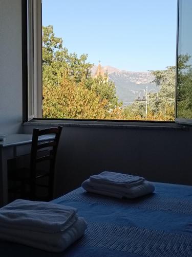 a room with a bed with a blue blanket and a window at bed and breakfast Murales Orgosolo in Orgosolo