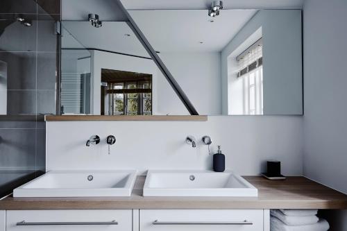 baño con 2 lavabos y espejo grande en Hygge Hus, en Oevenum