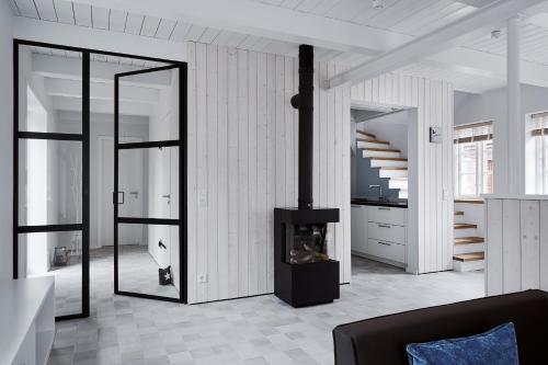 a living room with a fireplace and a staircase at Hygge Hus in Oevenum