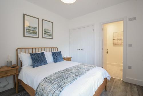 a bedroom with a large bed with blue pillows at Lyme Zest in Lyme Regis