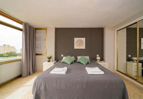 a bedroom with a large bed with two towels on it at Olivia's in Villajoyosa