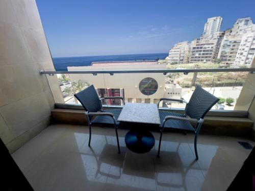 a balcony with a table and chairs and the ocean at Lancaster Suites Raouche in Beirut