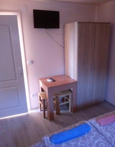 Cette chambre dispose d'une table, d'un bureau et d'une télévision. dans l'établissement Sobe Spaske, à Čačak
