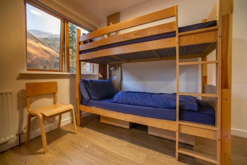 a bedroom with a bunk bed and a chair at Glen Nevis Youth Hostel in Fort William
