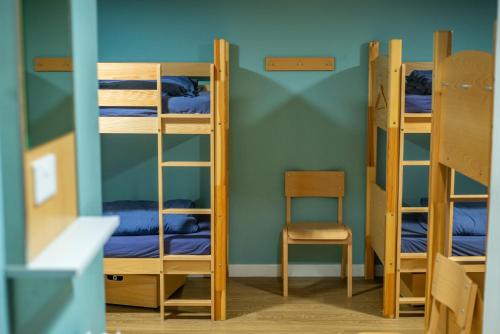 a room with three bunk beds and a chair at Glen Nevis Youth Hostel in Fort William
