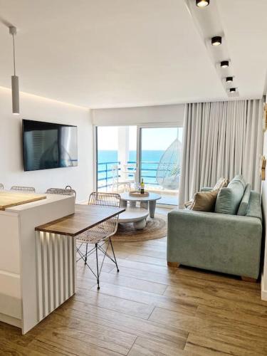 a living room with a couch and a table at Front Sea Apartment Quarteira in Quarteira