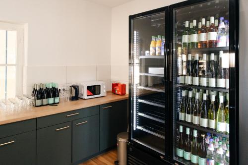 - un réfrigérateur rempli de nombreuses bouteilles de vin dans l'établissement Urige Schlaffässer im Winzergarten inklusive Weinprobe, à Bockenheim
