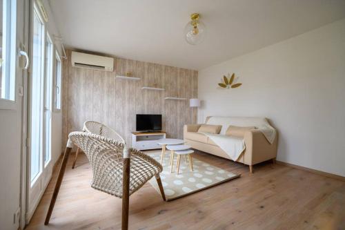 a living room with a couch and a table and chairs at Maison, 4 personnes, wifi, terrasse, jardin, piscine partagée in Coulounieix-Chamiers