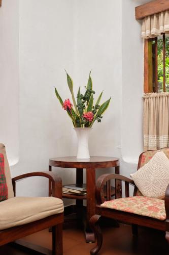 a vase of flowers on a table in a room at Vanilla County in Vagamon