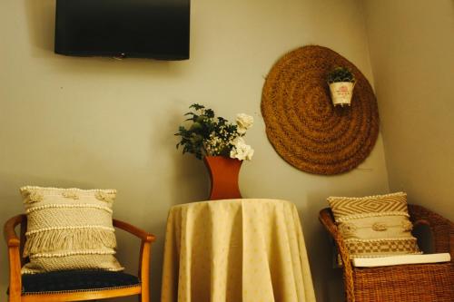 a vase with flowers on a table with two chairs at En-Suite Bedroom and Garage in Porto City Center in Porto