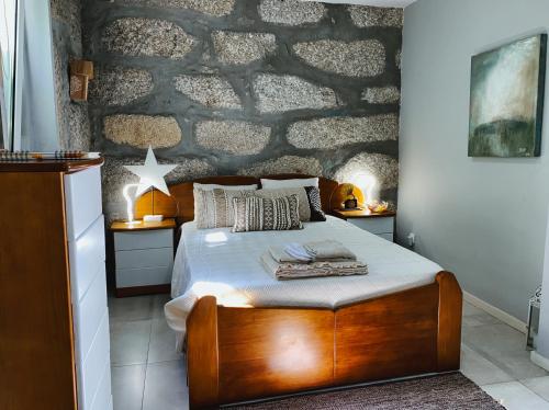 a bedroom with a wooden bed and a stone wall at En-Suite Bedroom and Garage in Porto City Center in Porto