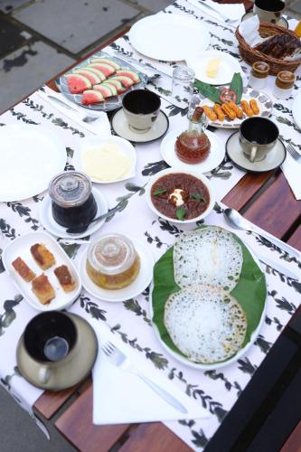 a table with plates and bowls of food on it at Vanilla County Heritage Plantation Bungalow in Vagamon