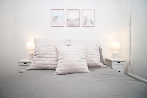 een witte slaapkamer met een bed met 2 lampen bij Central Mumbles Apartment, Properties By O & G, Incredible Location, Sleeps 4! in The Mumbles
