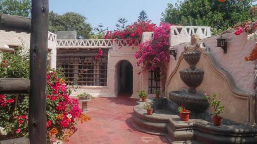 a courtyard with a statue and flowers in a building at Darenas Hacienda in Aucallama