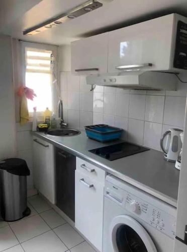 une cuisine avec une machine à laver et un évier dans l'établissement Chez Marie - 4p - Proche Paris - Metro 8, à Maisons-Alfort